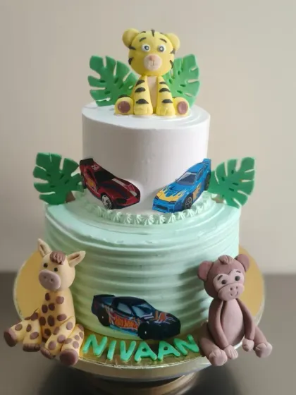 A fun two-in-one theme, combining animals and cars on a two-tier cake for a first birthday.