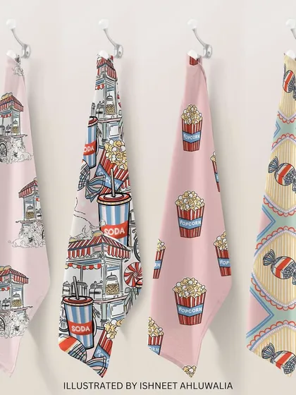My 'Funfair Frenzy' patterns printed on kitchen towels. These playful designs, featuring popcorn carts and sweet treats, can bring a touch of fun and colour to everyday items.