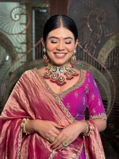 A beautiful smiling portrait in a plush, graceful magenta and purple lehenga.