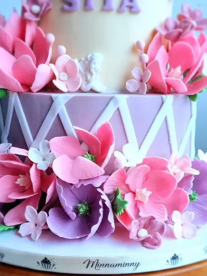 A close-up of the handmade sugar flowers on the two-tiered garden cake.