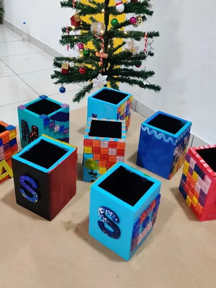 More examples of the finished pen stands, showcasing different mosaic patterns and color schemes created by the kids.