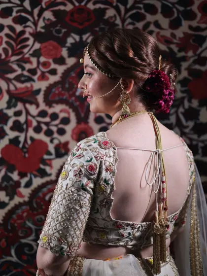 The back of the bridal look is just as important as the front. This view showcases the detailed embroidery of the blouse, the perfect draping of the dupatta, and the elegant floral bun.