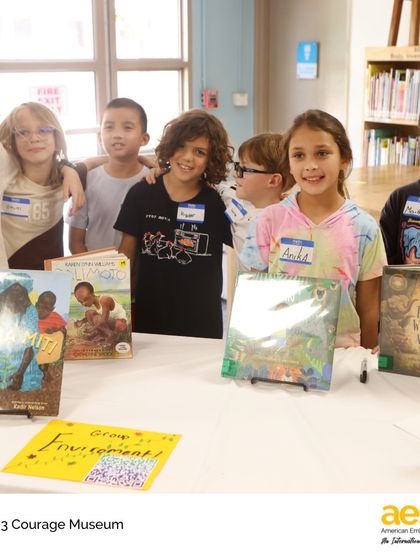 A group of proud third graders stands by their Courage Museum exhibit. Through this project, they learned that courage lives in everyday moments and that even the smallest voices can tell the biggest stories.