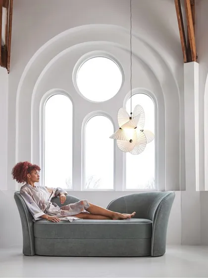 The large Serpentine Light in a serene, light-filled room. The fixture is created from elaborate twists and turns of a special paper material, diffusing the light beautifully.