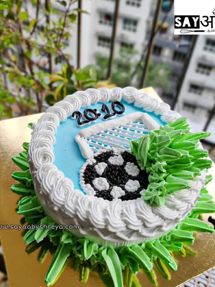 A simple yet effective football-themed cake. This design shows a soccer ball hitting the back of the net, a perfect "goal" for a birthday celebration.