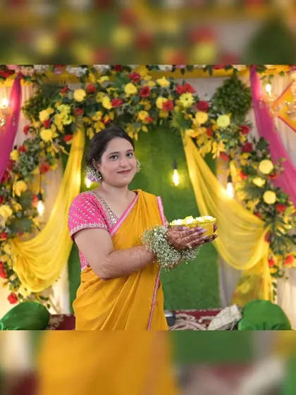 A portrait of the bride-to-be against our detailed Haldi backdrop. The combination of a grass wall, a floral arch, and draped fabrics provides a rich, textured background for photos.