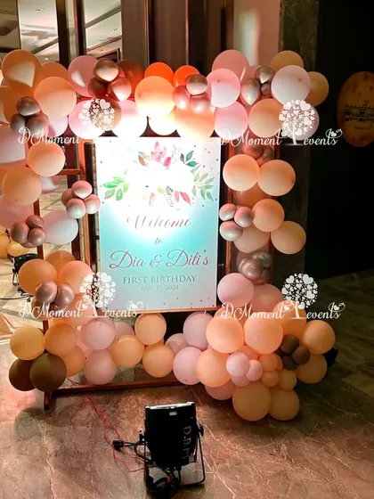 A welcome sign for twins Dia and Diti's first birthday. The sign is framed by a beautiful arrangement of balloons in a sophisticated, earthy color palette.