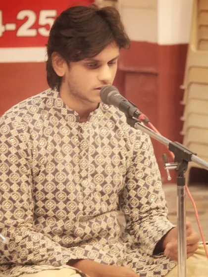 A student vocalist completely immersed in his performance. The stage is where practice transforms into a spiritual offering.