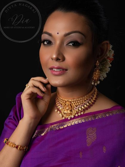 A direct and engaging portrait. The makeup is flawless, with a focus on clean skin and beautifully defined eyes, letting the traditional jewellery and her natural beauty stand out.