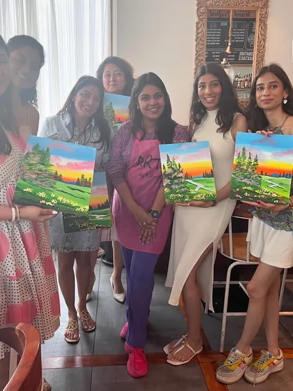 A group of ladies with their serene landscape paintings. A painting workshop is a great way to relax and de-stress.