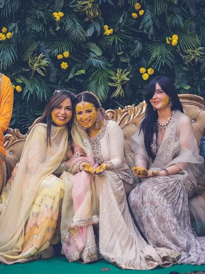 A lovely group portrait of the bride with her family and friends at her haldi ceremony.