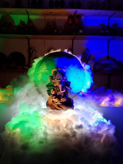 A creative shot of our Ganesha idol with colorful lights and smoke effects, creating a mystical and divine ambiance.