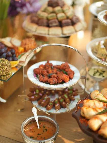 Tiered platters of hot appetizers, including seekh kebabs and fried chicken, ready for guests to enjoy.