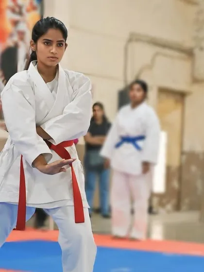 A focused gaze and a ready stance. This student is prepared to execute her kata with precision and power, embodying the spirit of karate.