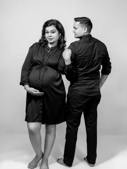 A candid-style black and white photo capturing a look between the couple. It feels natural and authentic, showing their bond as they prepare for parenthood.