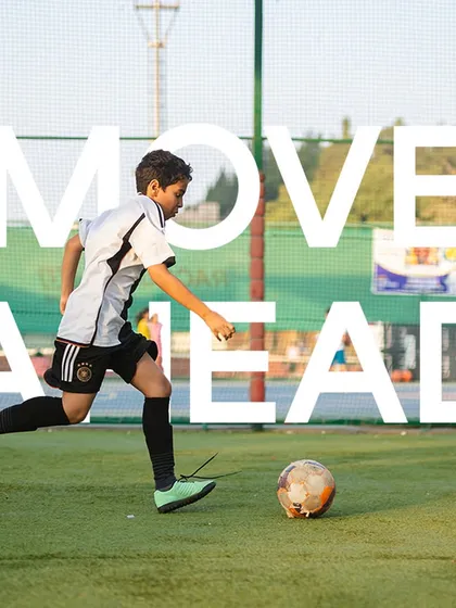 Every step on the field is a move forward. A young player dribbles with purpose, showcasing the drive and ambition that we encourage in all our athletes.
