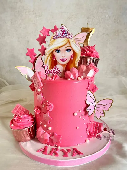 Come on Barbie, let's go party. This vibrant pink cake brings the iconic Barbie theme to life with stars, butterflies, and even mini cupcakes, creating a glamorous and fun centerpiece for a seventh birthday.
