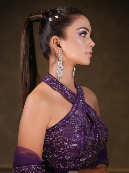A bold and fashionable look featuring a sharp purple wing liner and a sleek, high ponytail. This combination is perfect for a cocktail party or a glamorous night out.