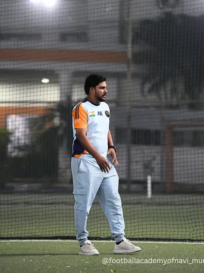 A coach observes a training session from the sidelines. Our staff is always analyzing and planning, ensuring every session is productive and tailored to our players' needs.