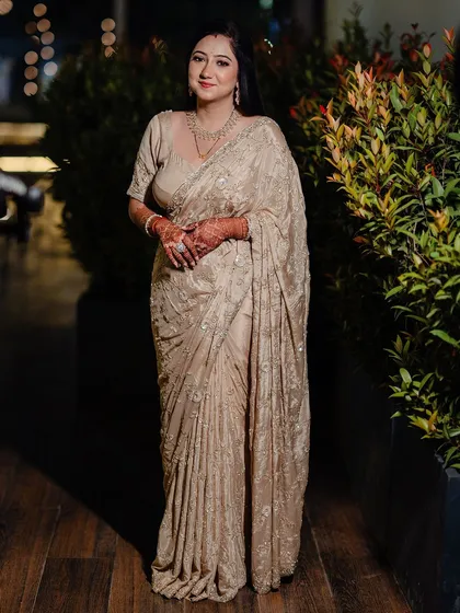 A full-length portrait of this bride in her elegant reception saree, her makeup looking soft and beautiful.