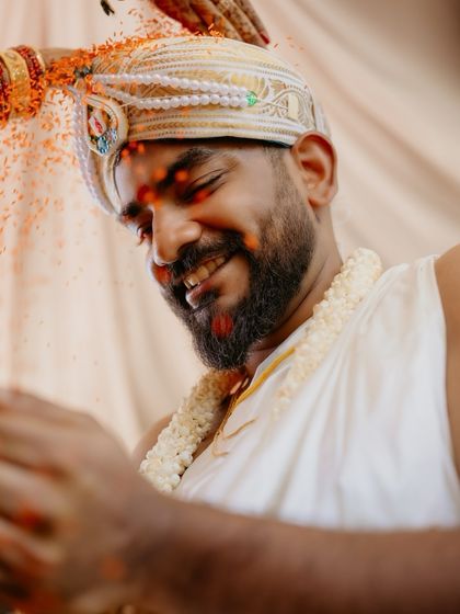 A tight, emotional shot of the groom during the Akshata ritual. Focusing closely on his expression captures the personal significance of the moment amidst the larger ceremony.