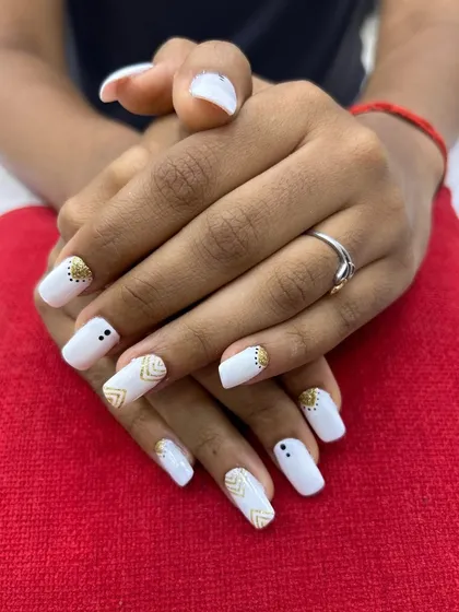 Simple yet elegant white nails with delicate gold geometric patterns. This design shows that even minimalist art can make a big impact.