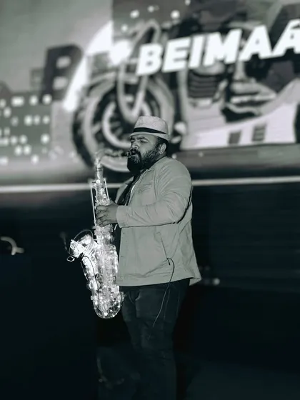 I often collaborate with other talented artists to elevate the experience. Here's a shot of a live saxophonist jamming along with my DJ set at a corporate event, adding a layer of live music to the party.