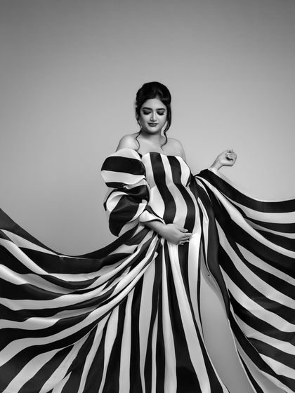 A study in black and white elegance. This shot captures the dramatic sweep of the striped gown, creating a sense of movement and high-fashion artistry. The monochrome edit makes it absolutely timeless.
