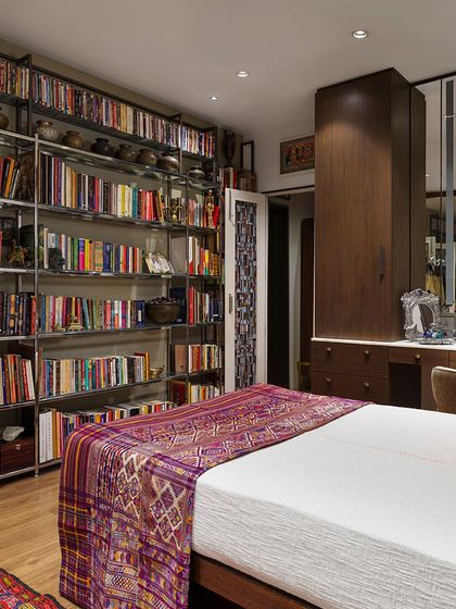 A view of the bedroom in the Courtyard Home, showing the custom dressing table and mirrored wardrobes. The space is highly functional, with ample storage, yet feels personal and curated with its collection of art and objects.