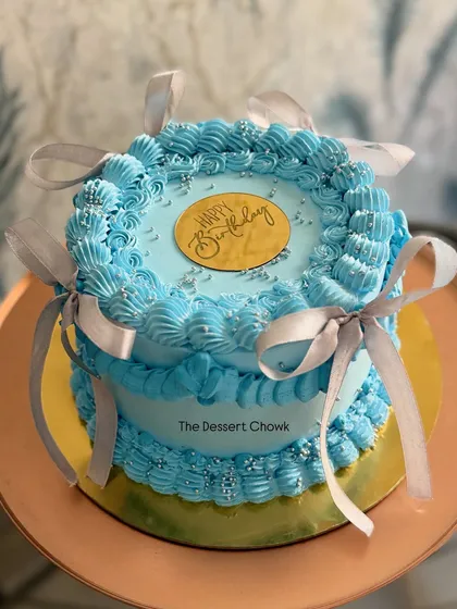 The full view of the blue vintage-style cake, tied with delicate ribbons.