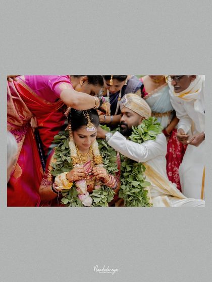 A sacred moment as the family blesses the couple during the wedding ceremony. The artistic framing highlights the intimacy and importance of the ritual.