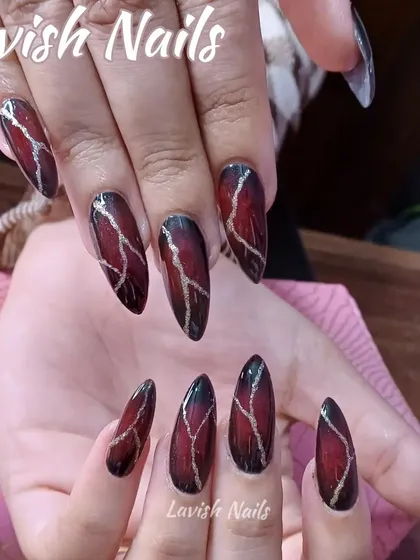 A dramatic and moody design with a red and black base and a gold crackle effect on stiletto nails.