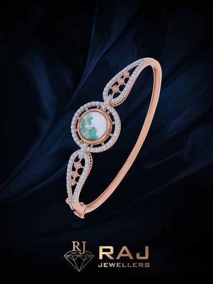 This modern bracelet features a central circular green stone on a sleek, open band. The design is clean and contemporary, ideal for everyday sophistication.