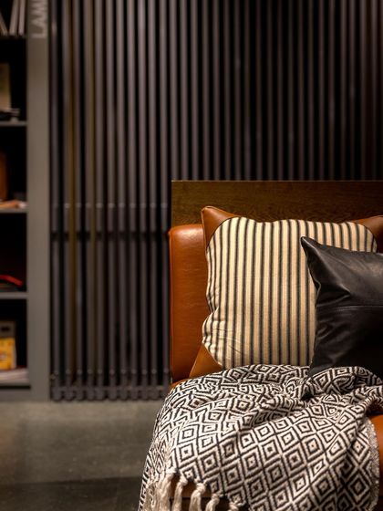 A detail of the comfortable leather seating, showing how we use soft textures to balance the hardness of the wood and concrete.