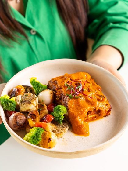 This dish features a flavorful curry with tender protein and a side of roasted vegetables. We use a blend of traditional spices and healthy cooking techniques to create meals that are both comforting and nutritious.