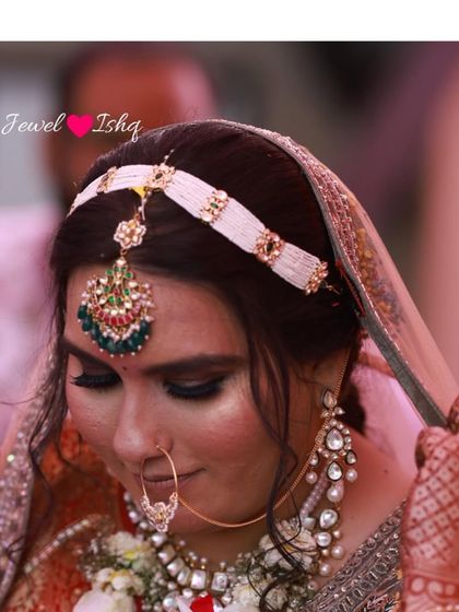 A close-up of a bride wearing a custom mathapatti, a delicate nath, and large pearl-drop earrings. This shows how I mix and match pieces for a unique look.