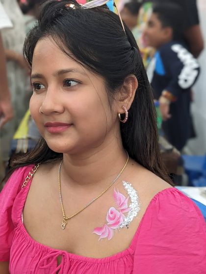 A beautiful pink rose design on the chest with a sweep of silver glitter.