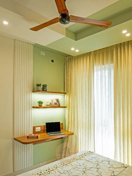 A transformation shot of a blank wall becoming a serene and stylish home workspace with a floating desk and backlit shelves.