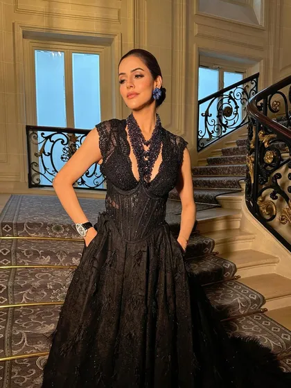 Another angle of this high-fashion look, showcasing the intricate details of the gown and the sophisticated makeup.