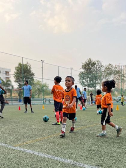 Young players navigate a cone drill during a training session. Our drills for this age group are designed as fun games to develop basic motor skills.