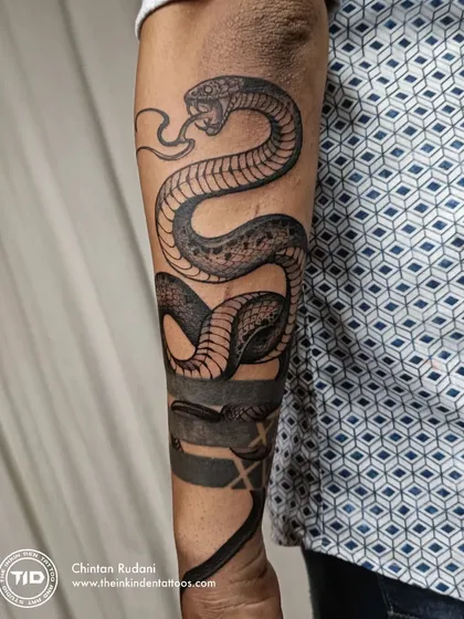 A full view of the snake tattoo on the forearm.