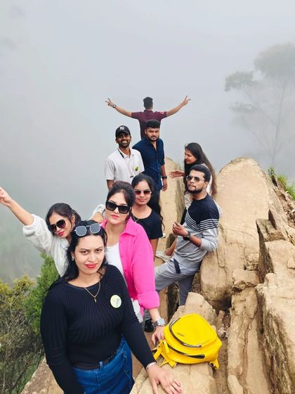 Posing on the Dolphin's Nose viewpoint in Kodaikanal. The foggy weather created a mystical and adventurous atmosphere for our group.