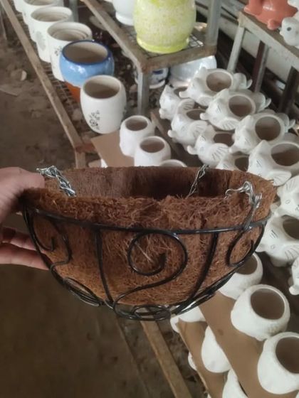 Another view of a coir hanging basket, with a variety of ceramic pots in the background, including my popular elephant-shaped planters.
