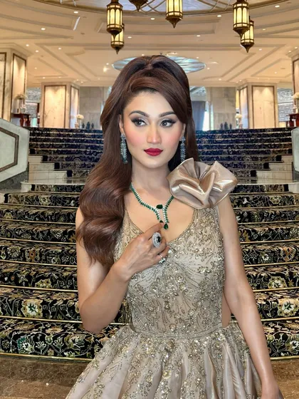 A dramatic half-up hairstyle with a high puff and flowing waves. This 'pretty doll' look is perfect for making a statement at a reception or cocktail party.