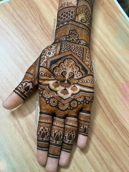 An intricate back-of-hand design with a central peacock motif. The dense patterns and detailed line work create a very rich and traditional look.