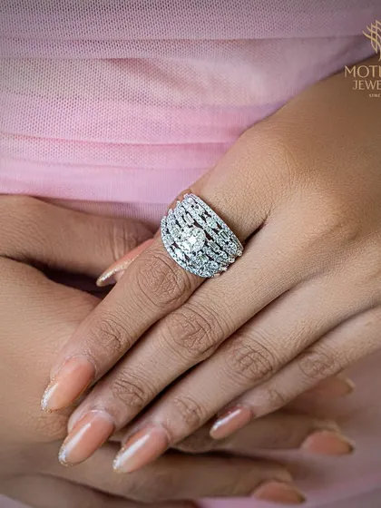 A model's hands adorned with a spectacular wide-band diamond ring, showcasing its impressive scale and sparkle.