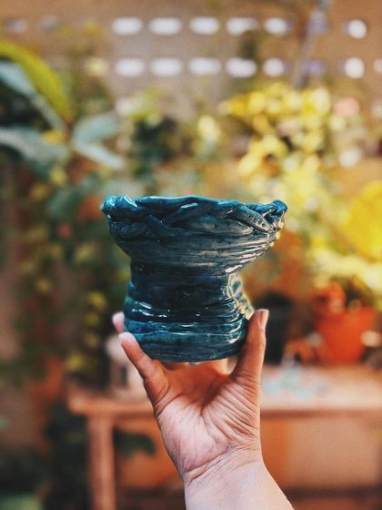 This dramatic, textured jar with a deep teal glaze was made by Stuti. It has so much movement and energy, it almost feels like a wave or a dragon.