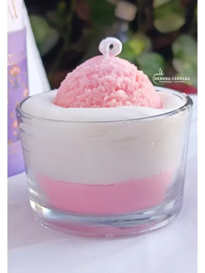 A pink ice cream scoop candle, featuring a single scoop of pink "ice cream" in a glass of white wax.