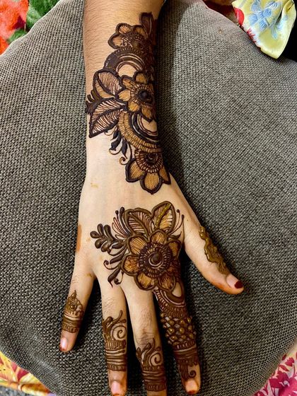 A lighter take on Arabic mehndi, with two separate floral motifs on the back of the hand and wrist. This is a great option if you want a festive look without full coverage.