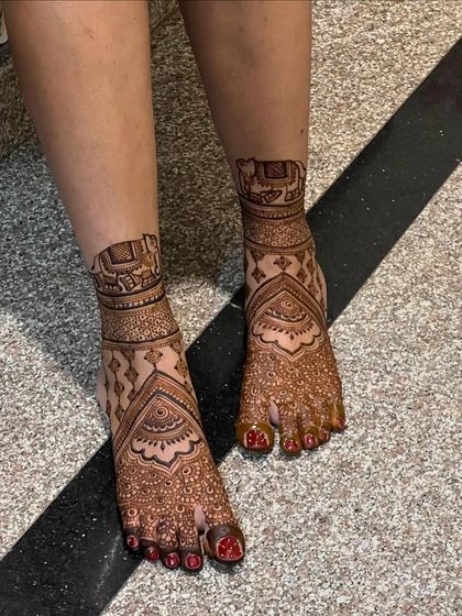 This bridal foot design features elephant motifs inside an architectural frame, symbolizing strength and good fortune.